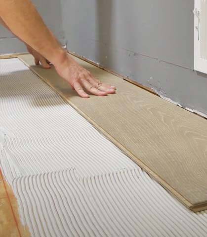 Installation of a timber board over adhesive